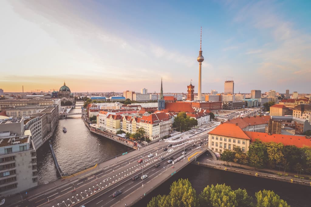 Panoramablick auf Berlin mit der Spree, Dom und Fernsehturm bei Sonnenuntergang.