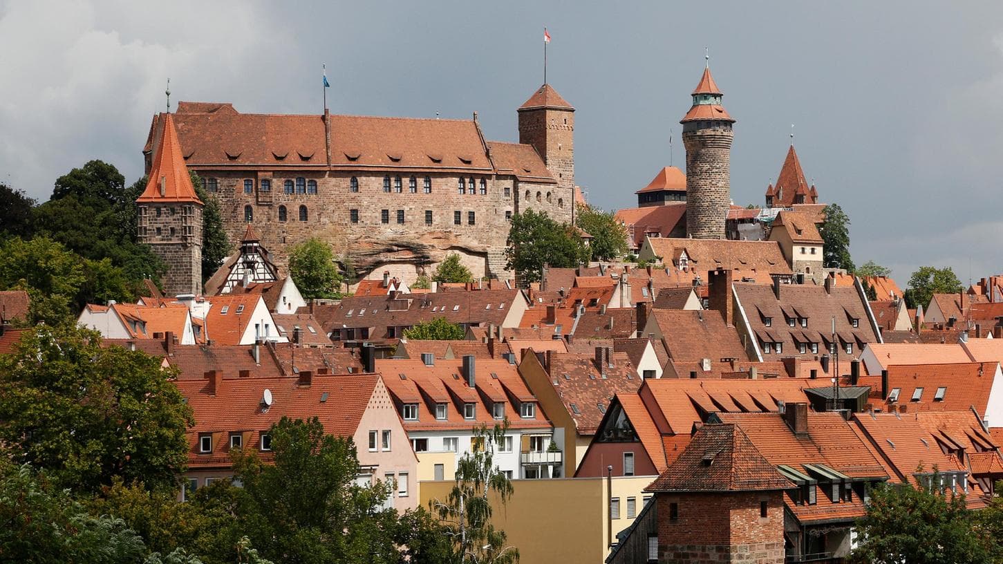 Nürnberger Kaiserburg über Altstadt mit Fachwerkhäusern und roten Dächern.